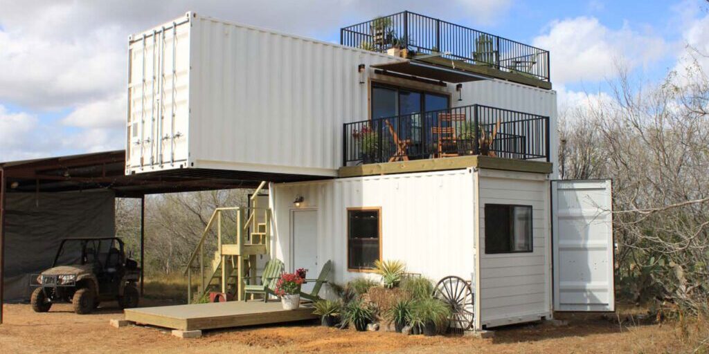 two story farmhouse made of container with a mountain view